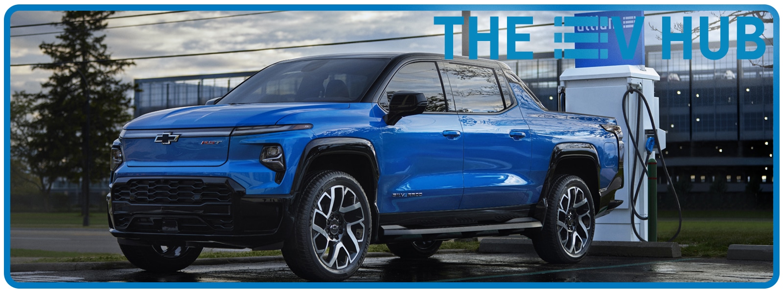 Blue Chevrolet electric pickup truck charging at a station, EV Hub backdrop.