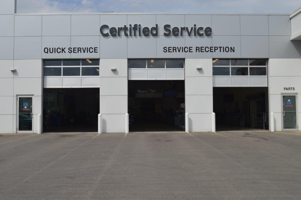 Auto service center entrance with quick service and parts department signs.