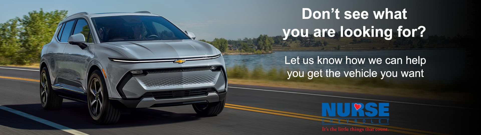 Silver Chevrolet SUV driving on a scenic road with dealership slogan and logo.