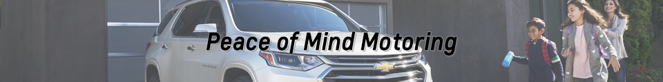 Family near a Chevrolet SUV with "Peace of Mind Motoring" text, highlighting safety and reliability.
