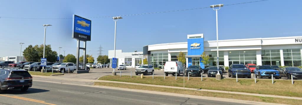 Chevrolet dealership with parked cars and showroom on a sunny day.