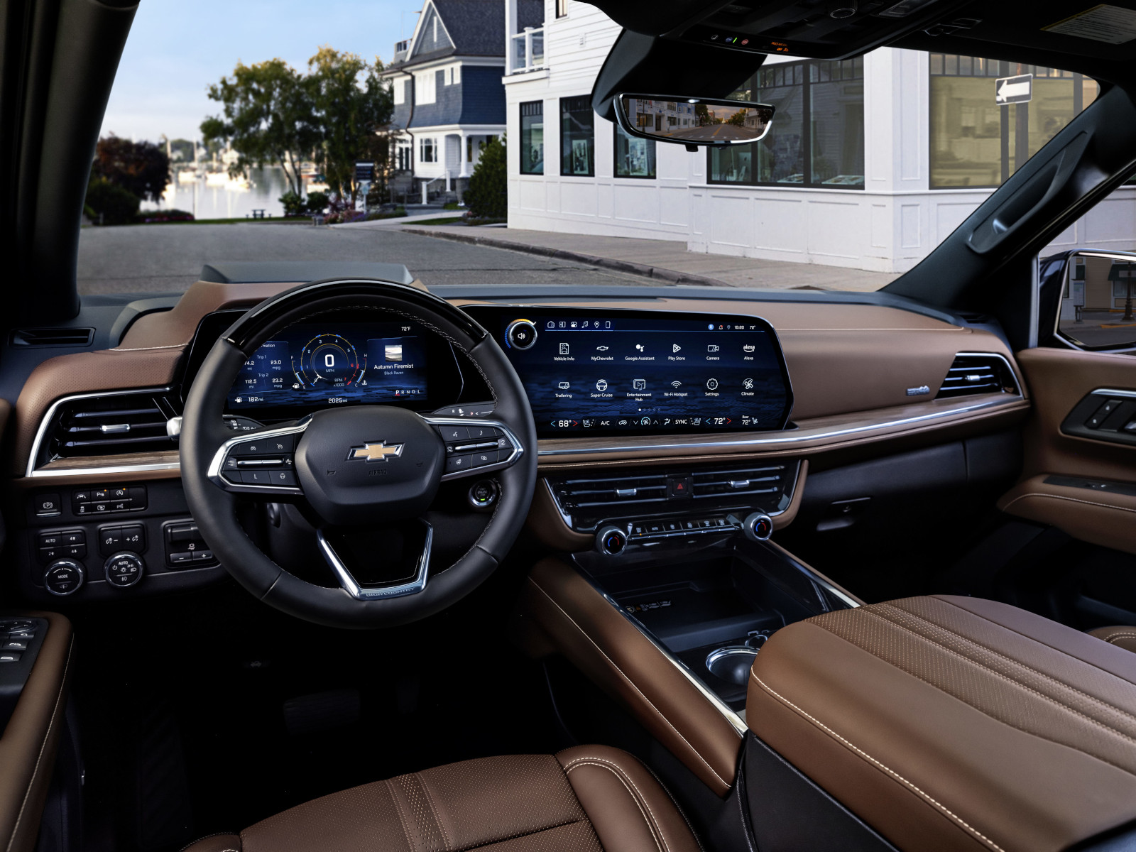 Luxury SUV interior featuring a modern dashboard, touchscreen displays, and brown leather seats.