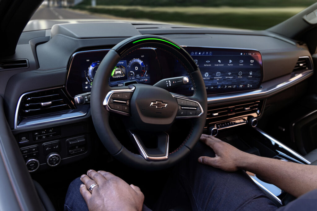 Modern Chevrolet car interior showing steering wheel, digital dashboard, and touchscreen controls.
