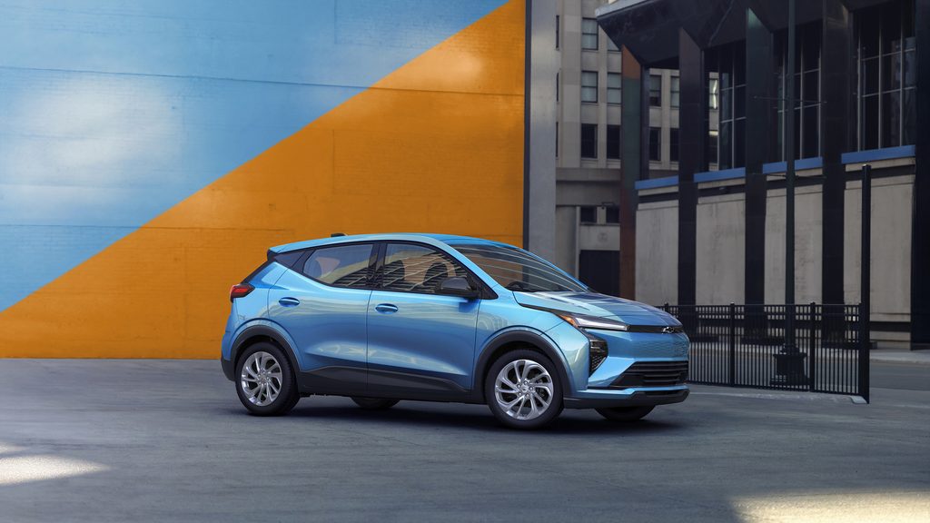Blue electric SUV parked in front of a colorful urban mural showcasing modern design.