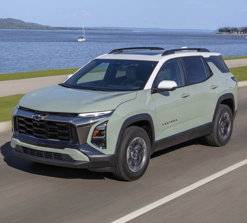 SUV driving by a scenic lakeside road on a sunny day, highlighting its sleek design and spacious interior.